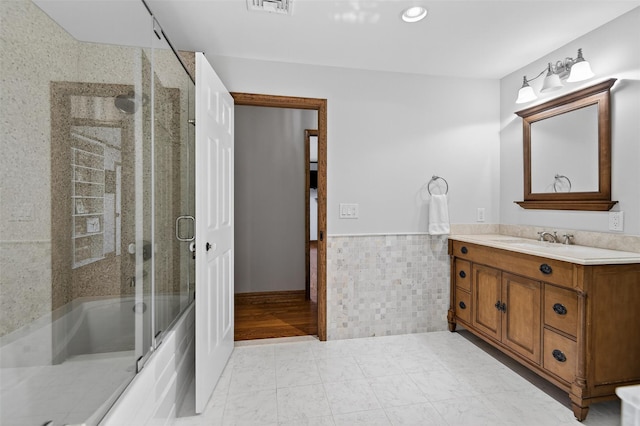 353 Split Rock Rd, Syosset, NY 11791 - bathroom with vanity, tile walls, shower / bath combination with glass door, and wainscoting