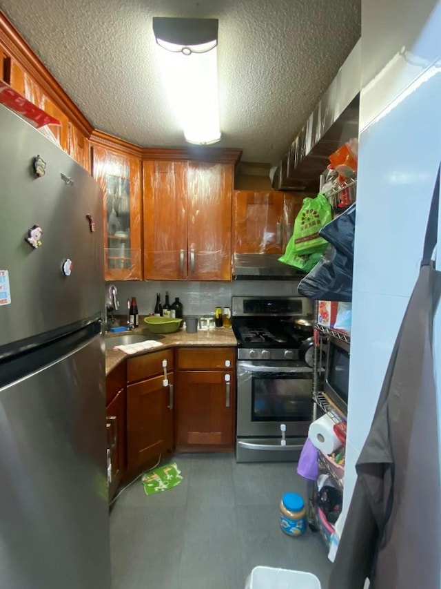 138-35 Elder Ave Unit 4B, Flushing, NY 11355 - kitchen featuring appliances with stainless steel finishes, a textured ceiling, brown cabinets, light countertops, and ventilation hood