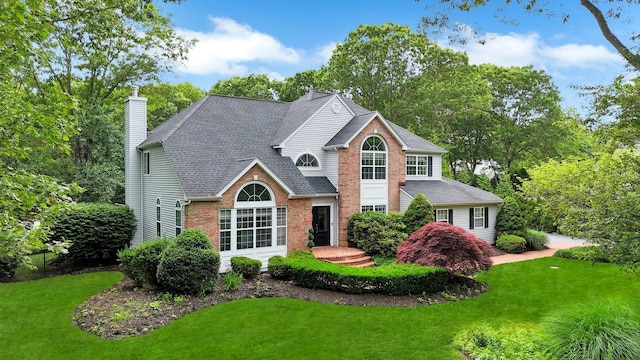 4 Scotch Pine Ln, East Setauket, NY 11733 - traditional home with a front lawn, brick siding, a shingled roof, and a chimney