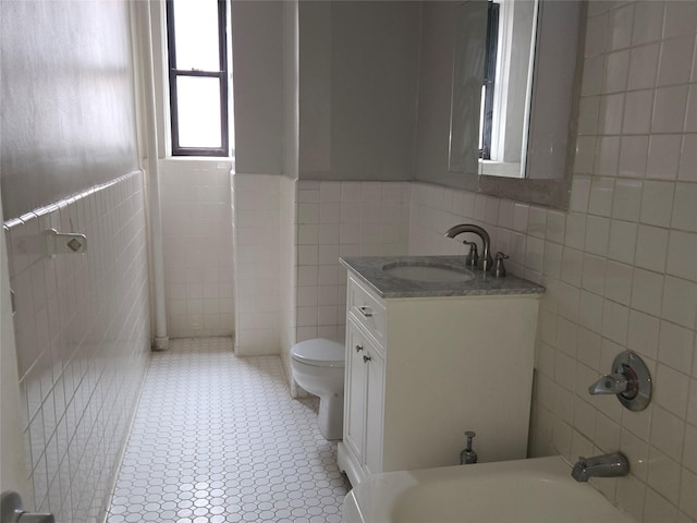 55 E 190th St Unit 45, Bronx, NY 10468 - full bath with tile walls, vanity, a wainscoted wall, and a tub to relax in