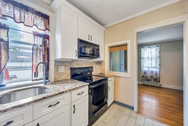 331 44th St, Lindenhurst, NY 11757 - kitchen featuring black appliances, backsplash, light wood finished floors, white cabinets, and light stone countertops