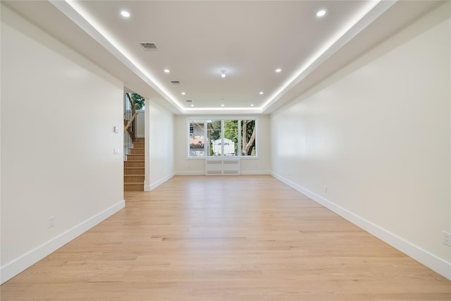 3 Jay St Unit 214, Spring Valley, NY 10977 - unfurnished room featuring stairway, recessed lighting, light wood-style floors, a raised ceiling, and radiator heating unit
