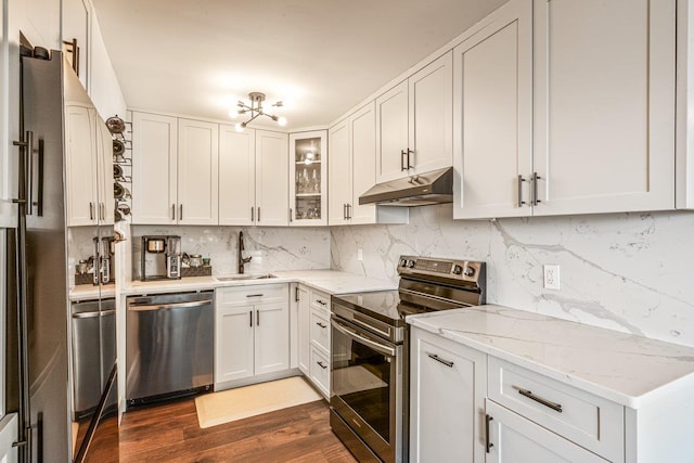 166-41 Powells Cove Blvd Unit 4B, Beechhurst, NY 11357 - kitchen featuring stainless steel appliances, under cabinet range hood, dark wood finished floors, backsplash, and glass insert cabinets