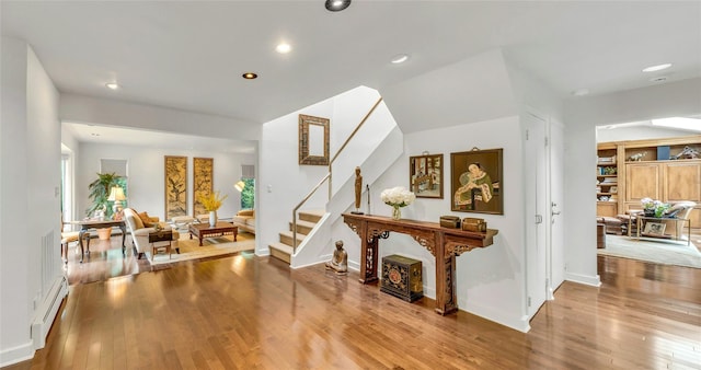 74 Woods Dr, Roslyn, NY 11576 - foyer with a baseboard heating unit, wood finished floors, recessed lighting, and stairway