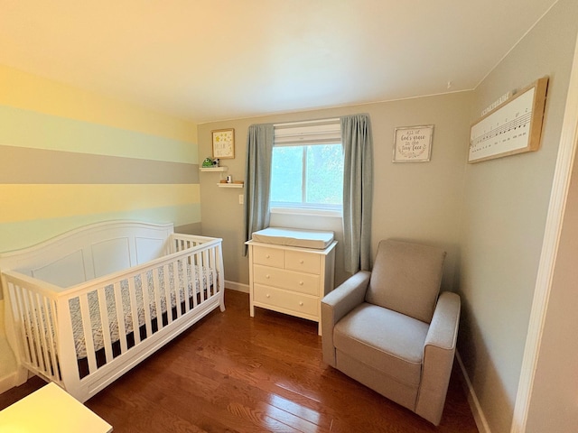 93 Holiday Park Dr, Centereach, NY 11720 - bedroom featuring wood finished floors and a crib