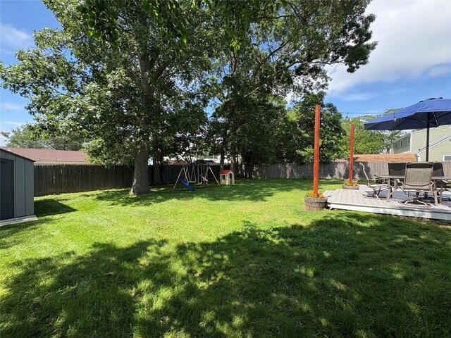 93 Holiday Park Dr, Centereach, NY 11720 - fenced backyard featuring a deck, outdoor dining space, and a shed