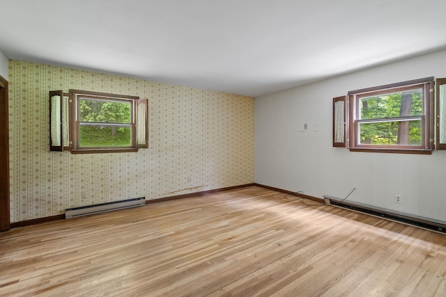 39 Knollwood Ln, Cold Spring, NY 10516 - empty room with baseboard heating, light wood finished floors, a baseboard radiator, and healthy amount of natural light