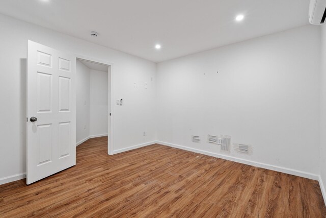 39 Knollwood Ln, Cold Spring, NY 10516 - empty room with a wall unit AC, light wood-style flooring, and recessed lighting