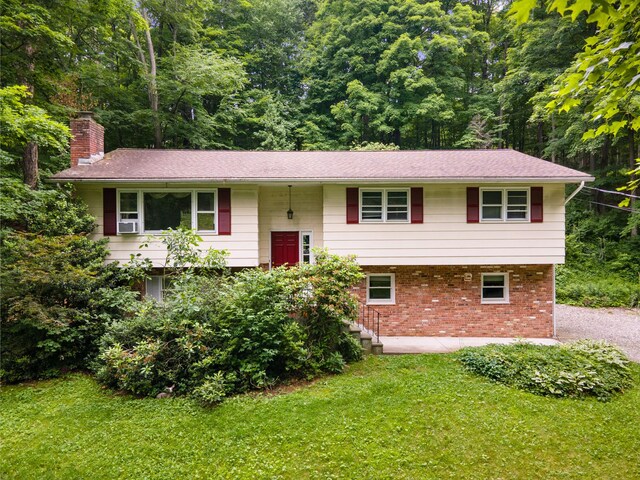 39 Knollwood Ln, Cold Spring, NY 10516 - bi-level home with a chimney, brick siding, a front yard, and cooling unit