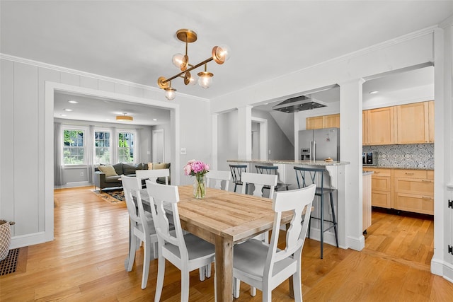 44 Kingsbury Rd, New Rochelle, NY 10804 - dining area featuring ornamental molding, light wood-style flooring, and decorative columns