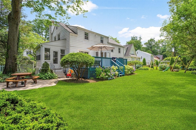 44 Kingsbury Rd, New Rochelle, NY 10804 - rear view of property featuring a lawn, a patio area, a deck, entry steps, and a playground