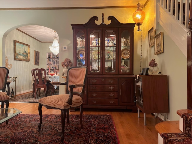 82-48 Eliot Ave, Middle Village, NY 11379 - living area featuring wood finished floors, arched walkways, ornamental molding, and a chandelier