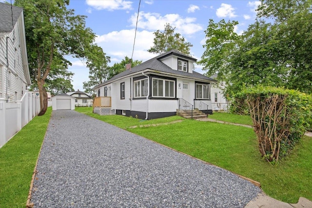 18 Evans Ave, Freeport, NY 11520 - bungalow-style house featuring gravel driveway, a detached garage, an outdoor structure, and roof with shingles