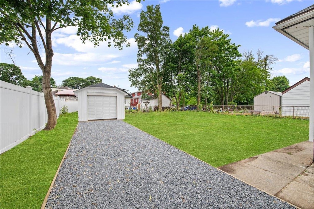 18 Evans Ave, Freeport, NY 11520 - view of yard featuring an outbuilding, driveway, and a garage