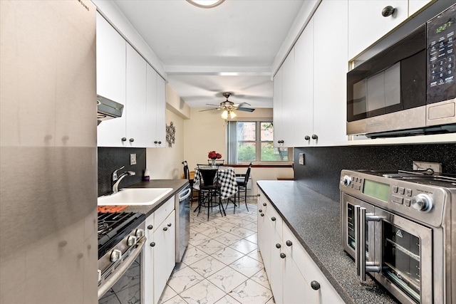 151-25 88th St Unit 1D, Howard Beach, NY 11414 - kitchen with stainless steel appliances, dark countertops, light marble finish flooring, and white cabinets