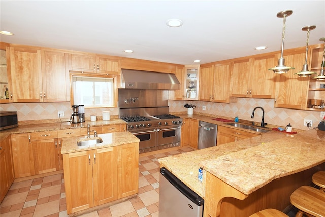 4723 164th St, Flushing, NY 11358 - kitchen with wall chimney range hood, stainless steel appliances, a breakfast bar area, a peninsula, and decorative backsplash