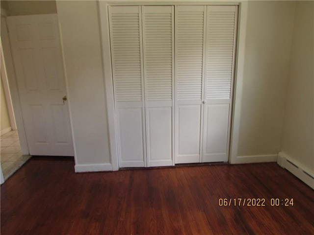 2 Leffingwell Pl, New Rochelle, NY 10801 - unfurnished bedroom featuring a closet, a baseboard heating unit, and dark wood-style flooring