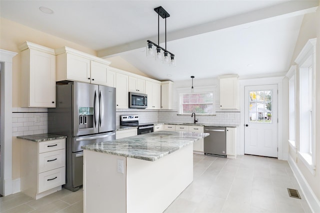 32 Reservoir Dr, Millbrook, NY 12545 - kitchen featuring appliances with stainless steel finishes, lofted ceiling, backsplash, a kitchen island, and light stone counters