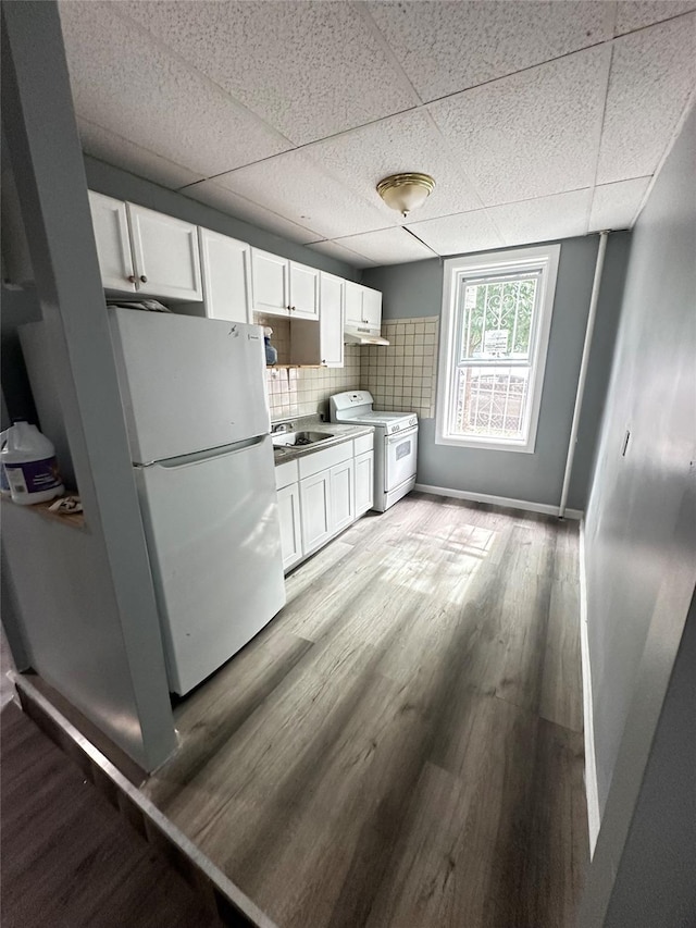 1661 E 172nd St, Bronx, NY 10472 - kitchen featuring white appliances, white cabinets, light wood-style flooring, a paneled ceiling, and decorative backsplash