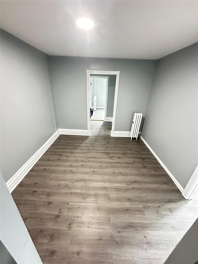 1661 E 172nd St, Bronx, NY 10472 - empty room featuring radiator heating unit and wood finished floors