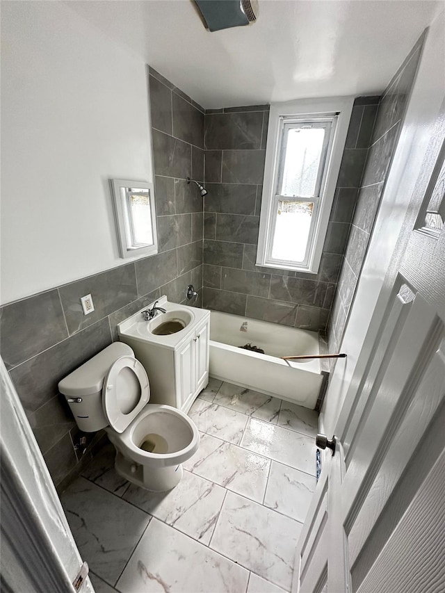 1661 E 172nd St, Bronx, NY 10472 - full bathroom with tile walls, marble look tile flooring, and shower / tub combination