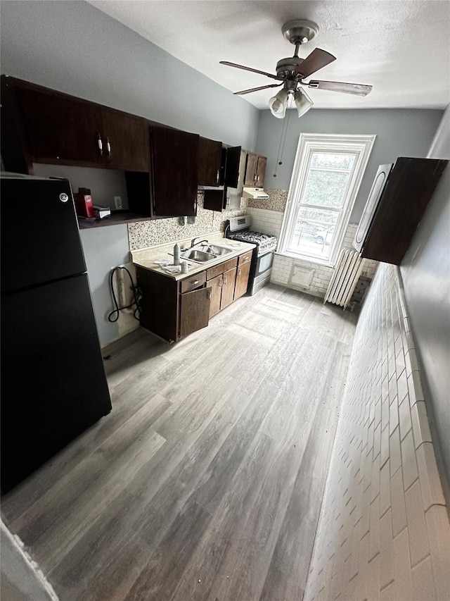 1661 E 172nd St, Bronx, NY 10472 - kitchen with freestanding refrigerator, gas stove, ceiling fan, light wood-style floors, and tasteful backsplash
