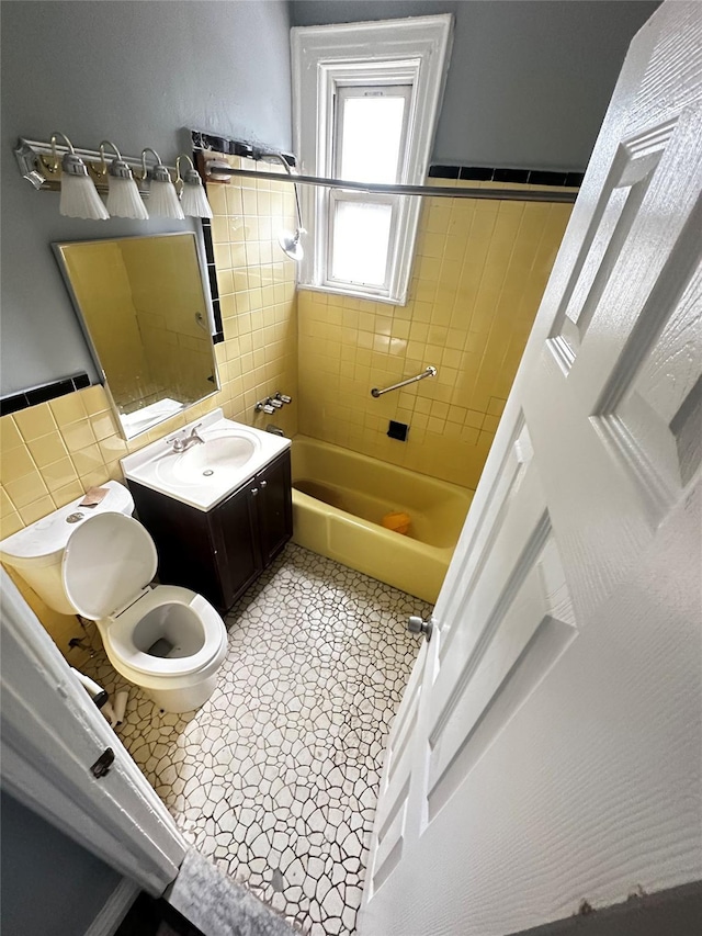1661 E 172nd St, Bronx, NY 10472 - full bathroom featuring tile walls, vanity, and tub / shower combination