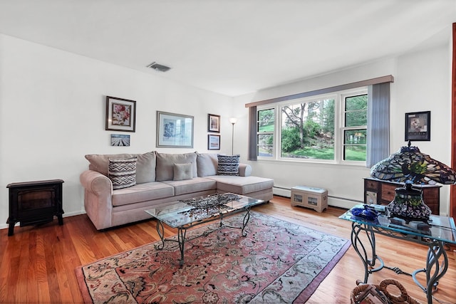 17 Woodrum Dr, Stony Point, NY 10980 - living room with a wood stove, wood finished floors, and a baseboard heating unit