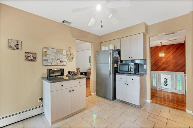 17 Woodrum Dr, Stony Point, NY 10980 - kitchen with a baseboard radiator, appliances with stainless steel finishes, wooden walls, a ceiling fan, and dark countertops