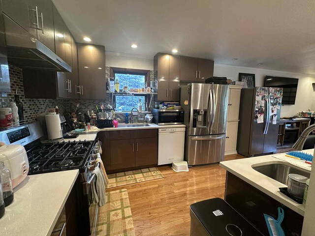2936 216th St, Bayside, NY 11360 - kitchen with appliances with stainless steel finishes, light countertops, ventilation hood, light wood-style floors, and tasteful backsplash