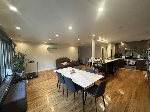 2936 216th St, Bayside, NY 11360 - dining area featuring a wall unit AC, light wood finished floors, and recessed lighting
