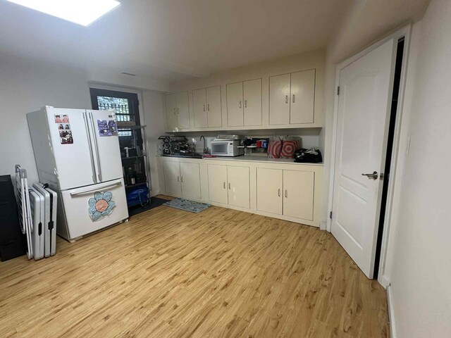 2936 216th St, Bayside, NY 11360 - kitchen featuring freestanding refrigerator, light wood-style floors, and white cabinetry