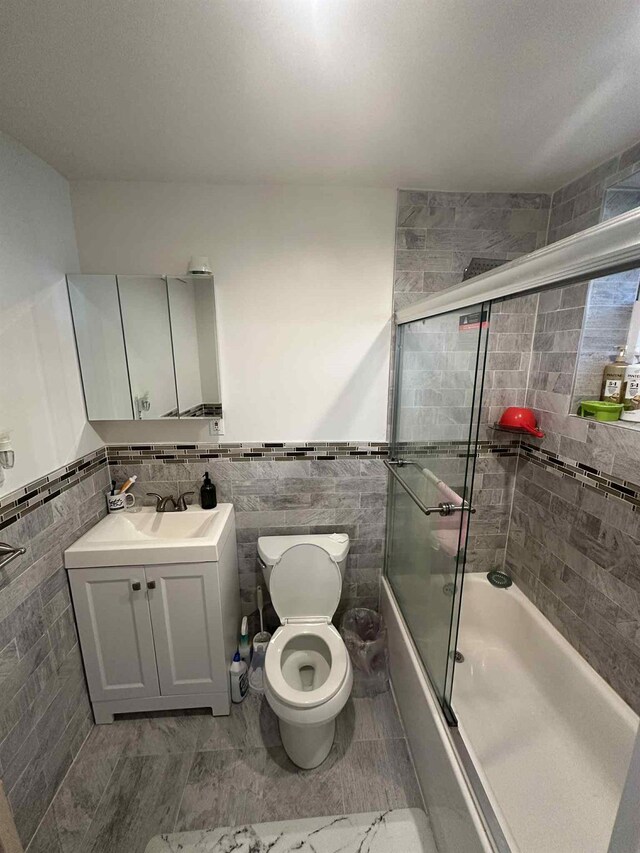 2936 216th St, Bayside, NY 11360 - full bath with enclosed tub / shower combo, tile walls, vanity, and a wainscoted wall