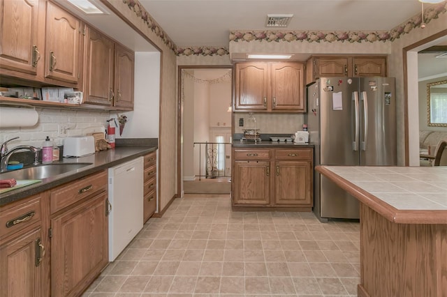 2 Valley View Cir, Warwick, NY 10990 - kitchen featuring dishwasher, freestanding refrigerator, backsplash, brown cabinetry, and tile countertops