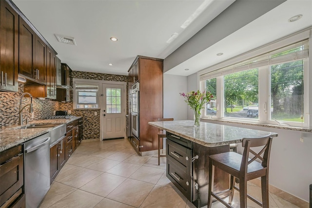 2 Janet Ln, Commack, NY 11725 - kitchen featuring stainless steel appliances, light tile patterned flooring, light stone countertops, backsplash, and recessed lighting