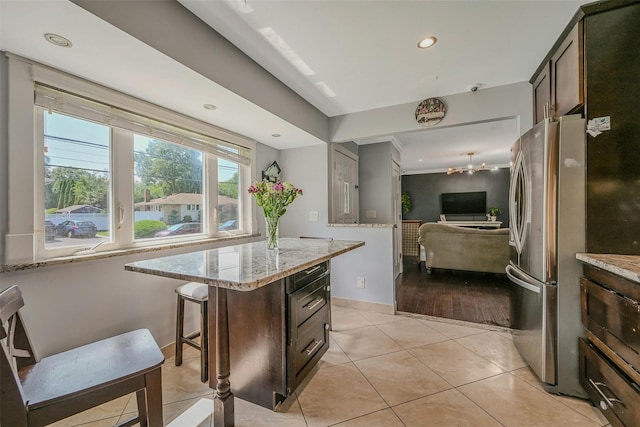 2 Janet Ln, Commack, NY 11725 - kitchen featuring freestanding refrigerator, light stone countertops, light tile patterned floors, dark brown cabinetry, and open floor plan