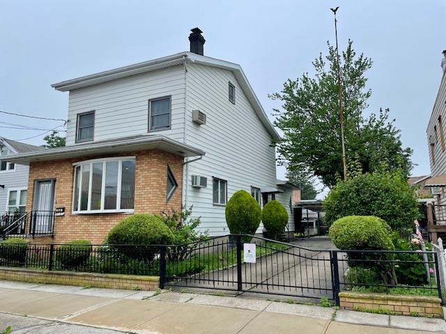 53-80 72nd Pl, Maspeth, NY 11378 - view of front of property with brick siding, a fenced front yard, a chimney, and a gate