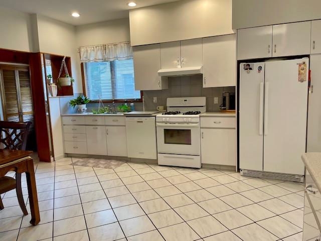 53-80 72nd Pl, Maspeth, NY 11378 - kitchen with white appliances, under cabinet range hood, decorative backsplash, light countertops, and recessed lighting