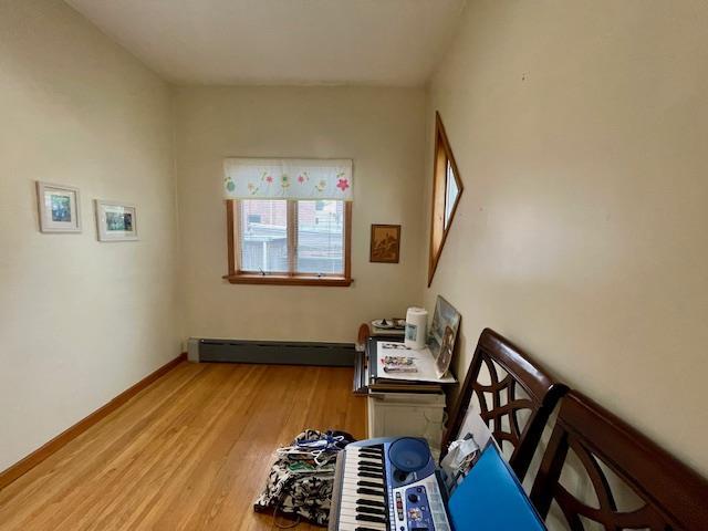 53-80 72nd Pl, Maspeth, NY 11378 - staircase with a baseboard heating unit and wood finished floors