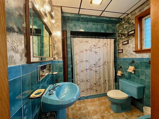 53-80 72nd Pl, Maspeth, NY 11378 - bathroom featuring tile walls, tile patterned flooring, a shower with curtain, wallpapered walls, and a wainscoted wall