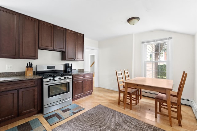 160 Newtown Ln, East Hampton, NY 11937 - kitchen featuring stainless steel gas range oven, light wood finished floors, dark brown cabinets, vaulted ceiling, and dark stone counters