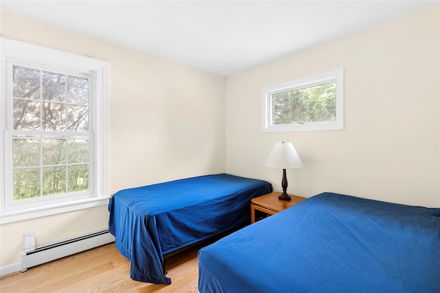 160 Newtown Ln, East Hampton, NY 11937 - bedroom featuring a baseboard heating unit and wood finished floors