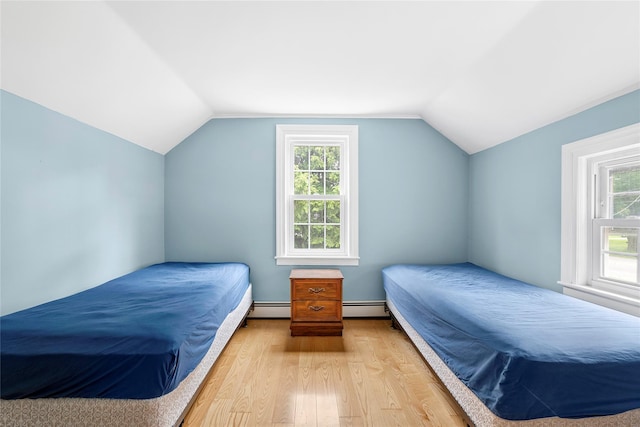 160 Newtown Ln, East Hampton, NY 11937 - bedroom featuring wood finished floors, a baseboard heating unit, multiple windows, and vaulted ceiling