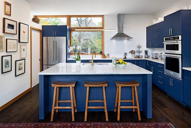 34 Old Neck Rd S, Center Moriches, NY 11934 - kitchen with appliances with stainless steel finishes, blue cabinets, wall chimney exhaust hood, a breakfast bar, and dark wood-style floors