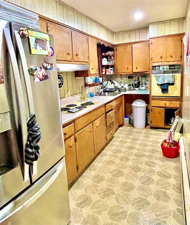20 Pine Ave, Ossining, NY 10562 - kitchen with white appliances, light countertops, stone floors, under cabinet range hood, and brown cabinetry