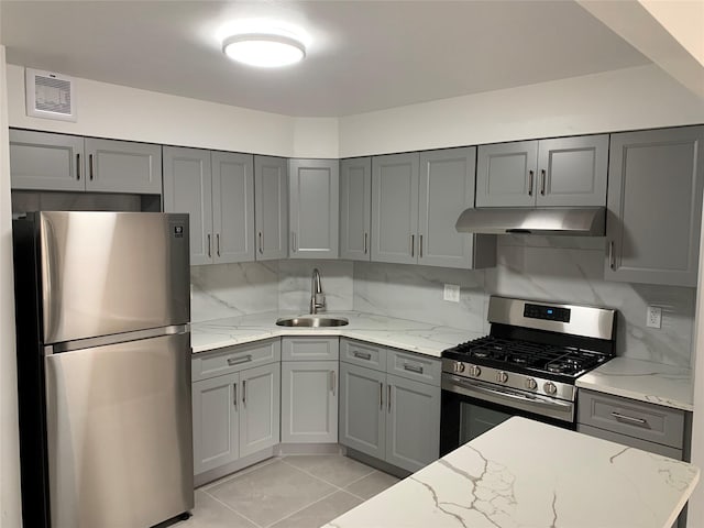 5323 82nd St, Elmhurst, NY 11373 - kitchen featuring appliances with stainless steel finishes, under cabinet range hood, gray cabinets, and light stone counters
