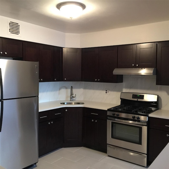 5323 82nd St, Elmhurst, NY 11373 - kitchen featuring appliances with stainless steel finishes, under cabinet range hood, light countertops, light tile patterned flooring, and backsplash