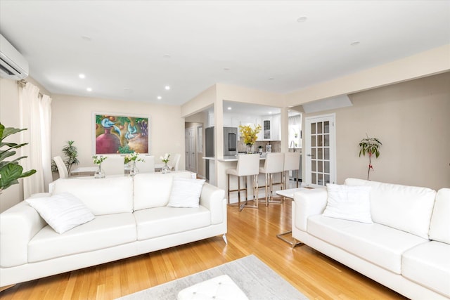 1159 129th St, College Point, NY 11356 - living room with a wall unit AC, light wood finished floors, and recessed lighting