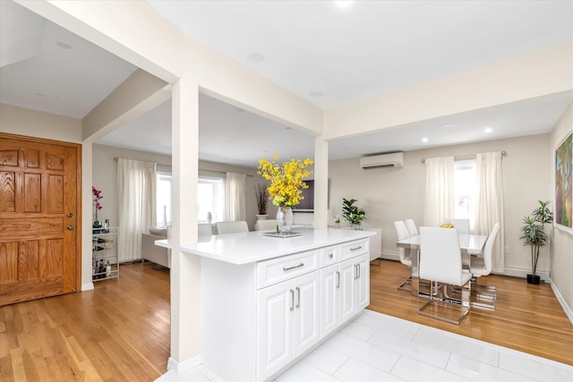 1159 129th St, College Point, NY 11356 - kitchen featuring healthy amount of natural light, a wall mounted air conditioner, light countertops, white cabinets, and recessed lighting