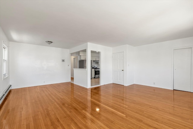 1159 129th St, College Point, NY 11356 - unfurnished living room with light wood-style floors and a baseboard heating unit